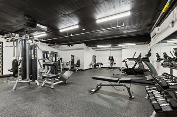 a gym with weights and other equipment in a building with black ceilings at Rialto, District of Columbia